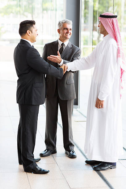 Business professionals conducting handshake during international cybersecurity consulting engagement and partnership discussion