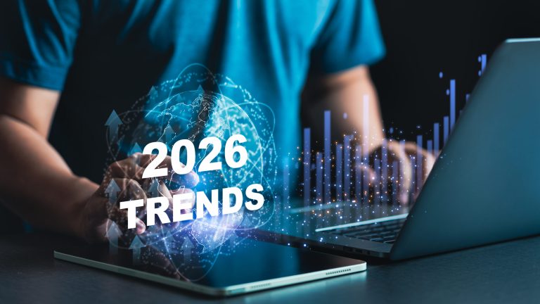 Technology professional analyzing 2026 digital trends with holographic globe, growth charts, and emerging technologies on laptop screen