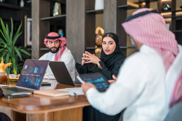 Middle Eastern cybersecurity team discussing risk management and digital transformation strategy in modern office environment