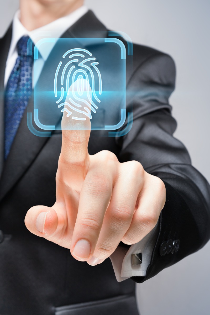Businessman in suit pressing finger on holographic fingerprint scanner for biometric authentication and identity access
