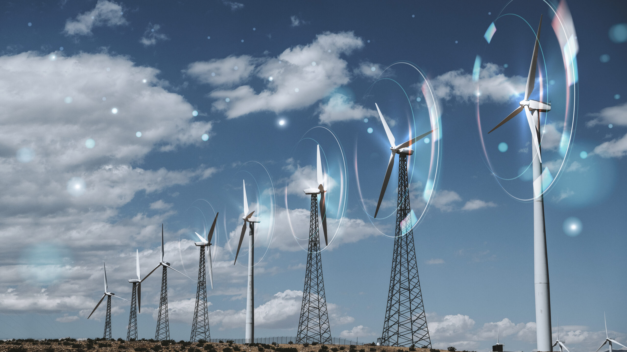 Wind turbine farm under blue sky with digital glow effects symbolizing smart renewable energy and IoT integration